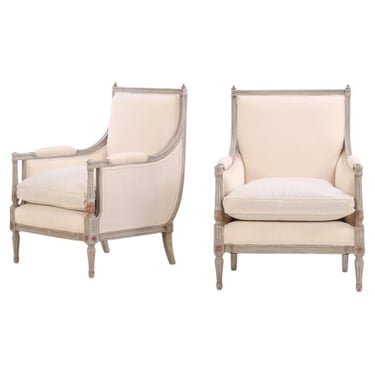 A pair of Louis XVI style grey painted and partial gilt Bergere chairs, C. 1940.
