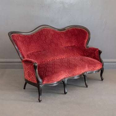 1850's French Napoleon III Hand Carved Settee Featuring a Raised Crimson Velvet Damask Upholstery & Traditional Black Frame