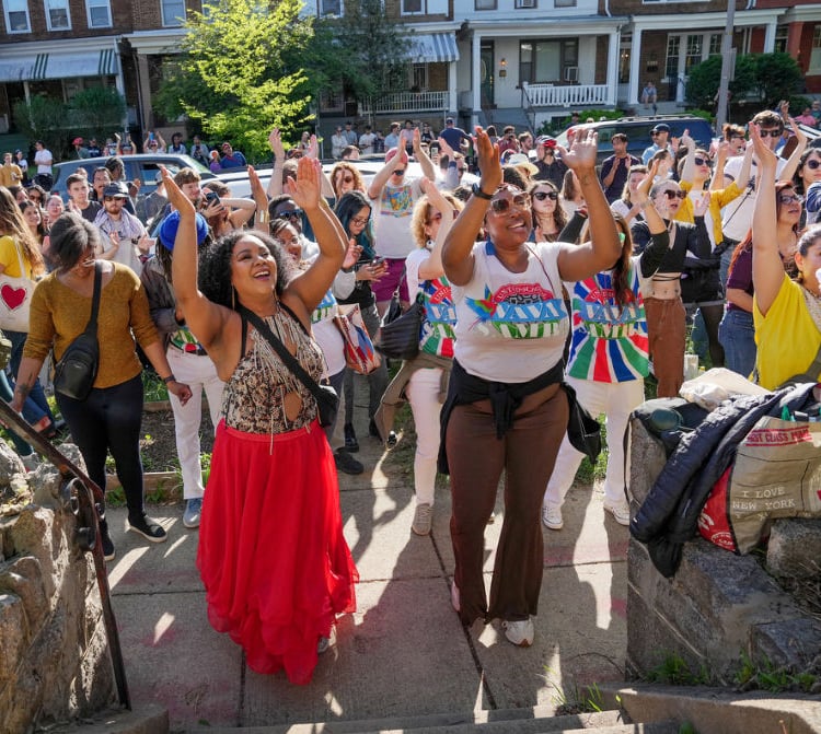 People dancing in the street in front a porchfest performance