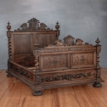 1830’s French Ornate Hand Carved Oak Queen-Sized Bed, Likely from Normandy, Featuring Extensive Floral & Foliate Carvings Throughout w/ Barley Twists Posts and a Crest Motif