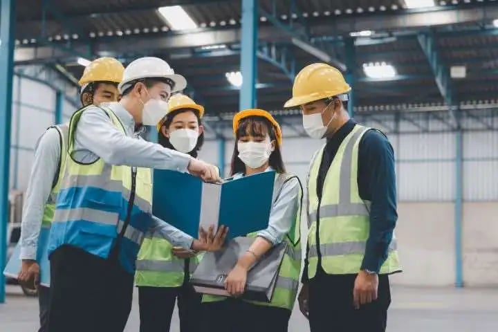 Hard-hatted workers in hi-vis discussing on site