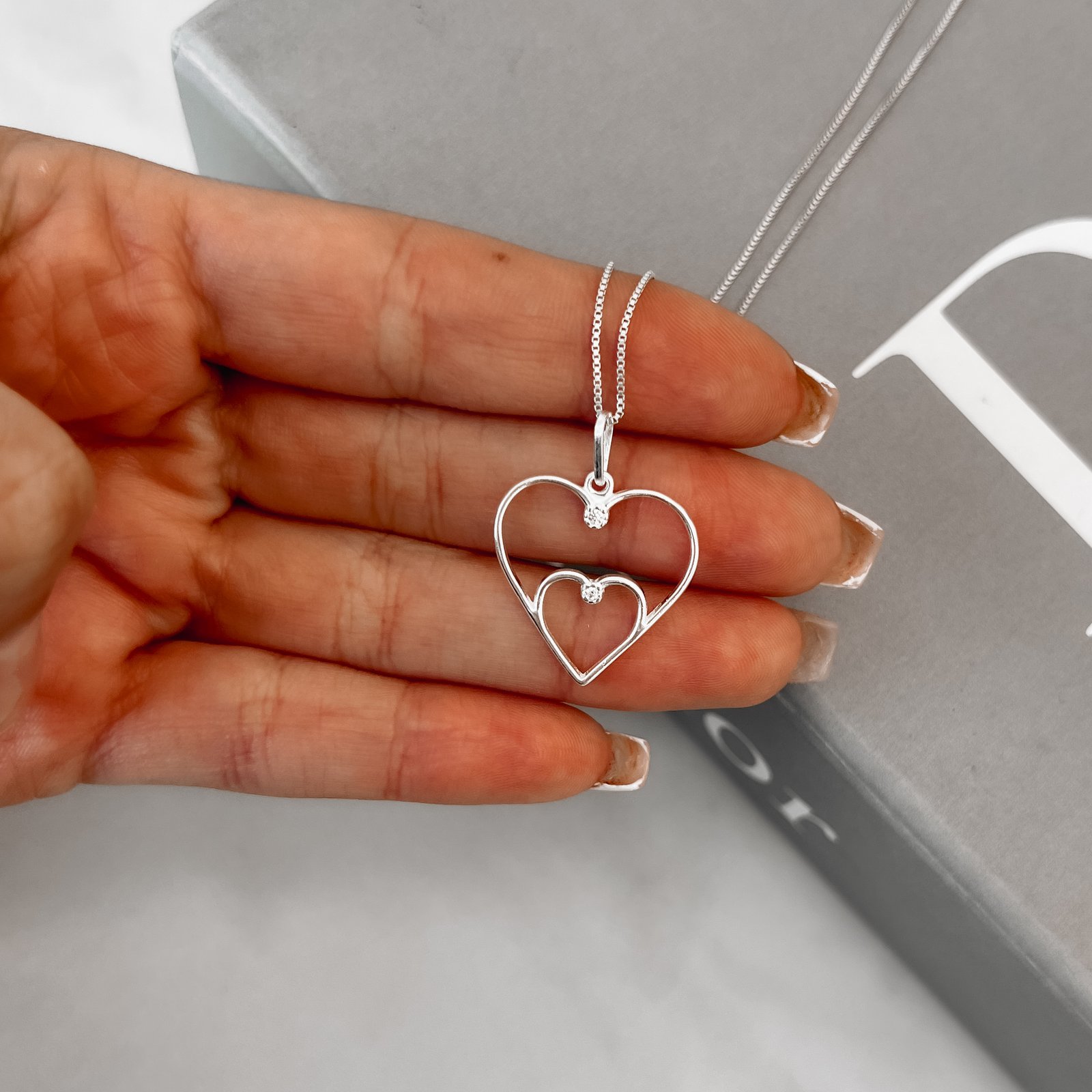 Colar pingente dois corações vazados com zircônia 21mm 45cm