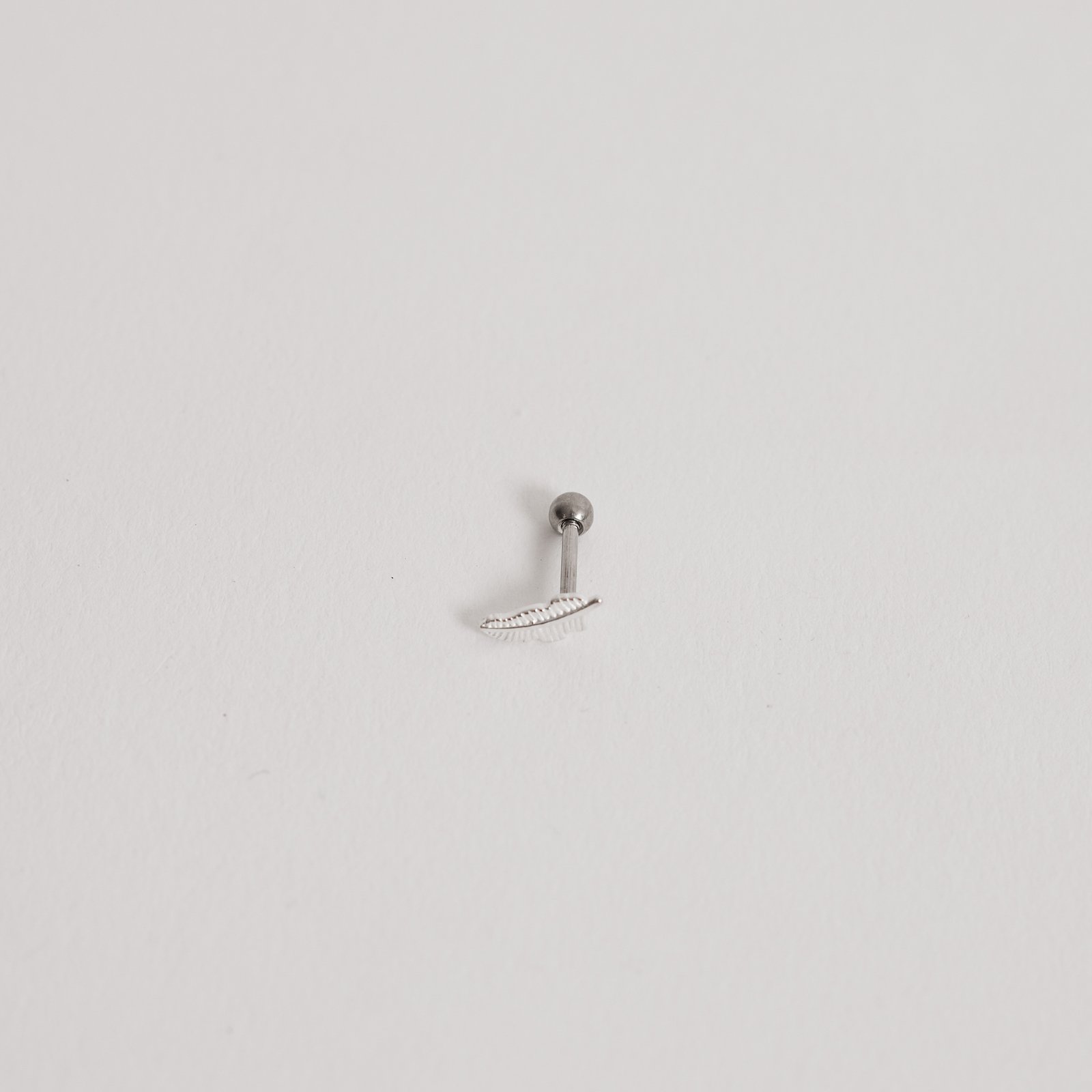 Piercing haste pena 8mm orelha esquerda