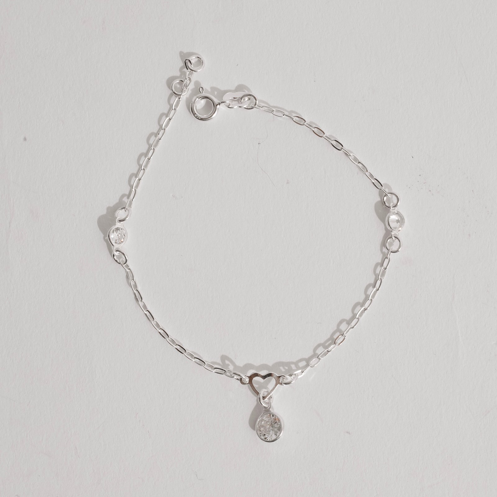 Pulseira entremeios coração vazado e zircônias com pingente zircônia 7mm 19cm