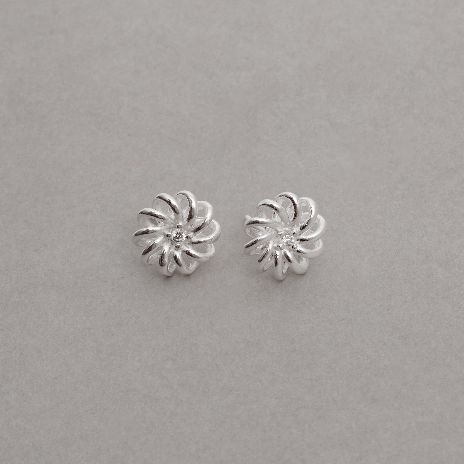 Brinco flor vazada detalhe zircônia 10mm