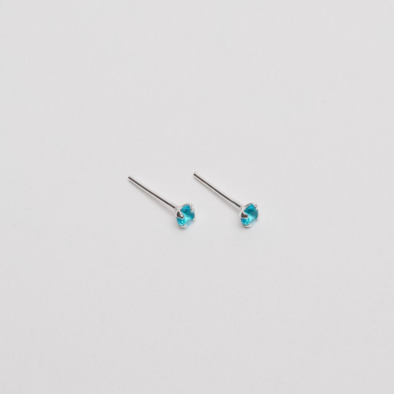 Brinco zircônia redonda azul 3mm garra