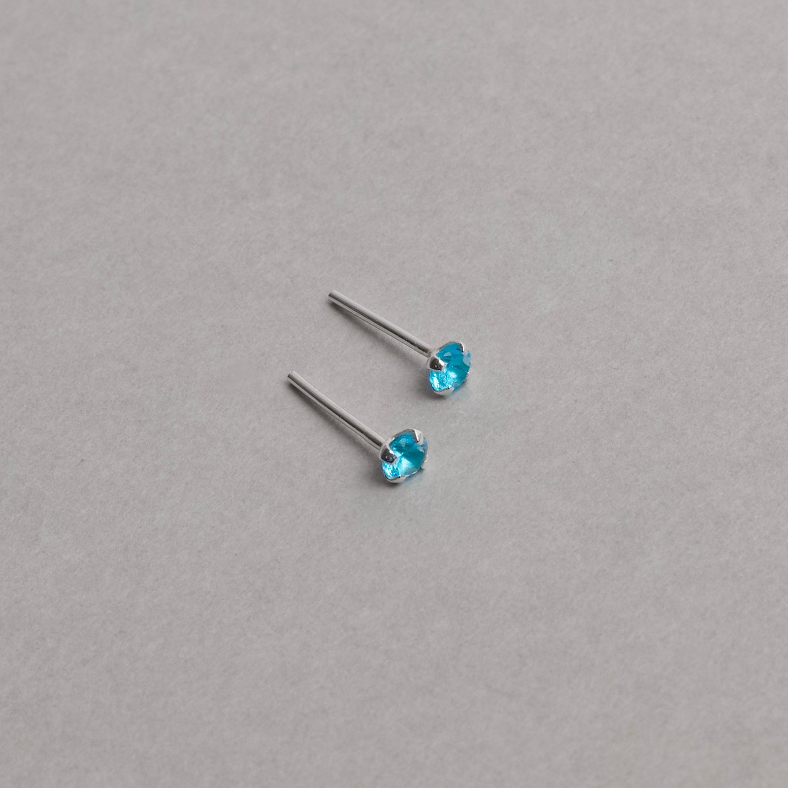 Brinco zircônia redonda azul 3mm garra