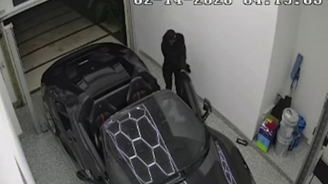 Un Ferrari Spider Negro Se Desvanece en la Noche de Miami Bajo la Mirada de una Cámara