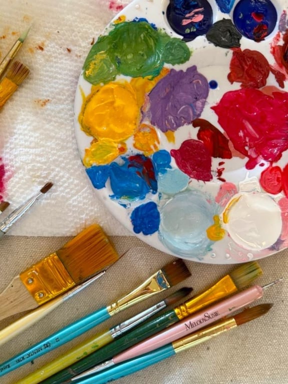 Paleta de pintura y pinceles sobre el lienzo