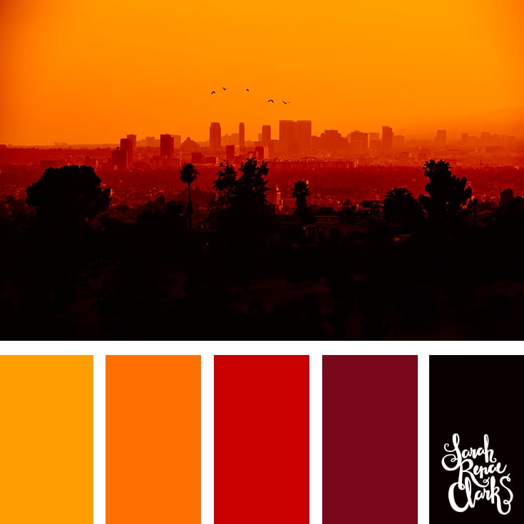 Color Palette #286 - a hazy cityscape silhouetted in fiery reds and oranges from the sunset.