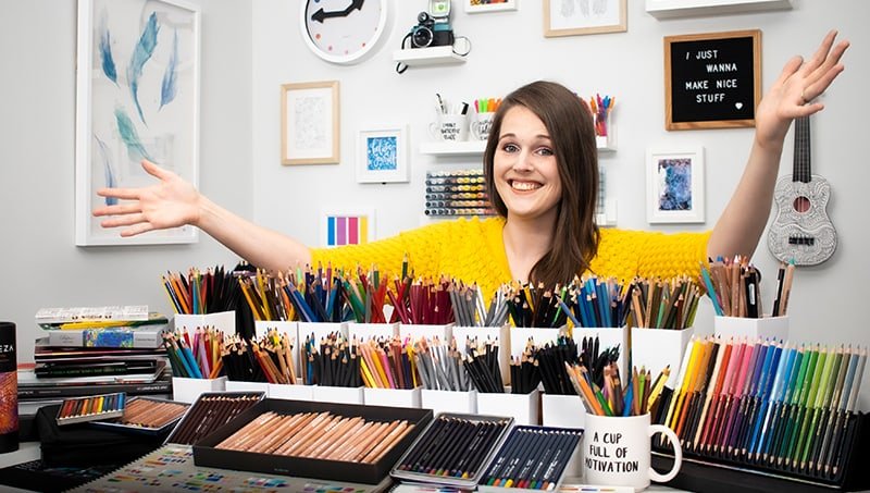 Sarah Renae Clark with lots of colored pencils in art studio
