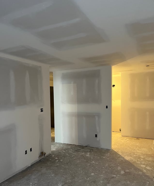 Newly installed drywall panels on wall framing, showing clean professional installation work