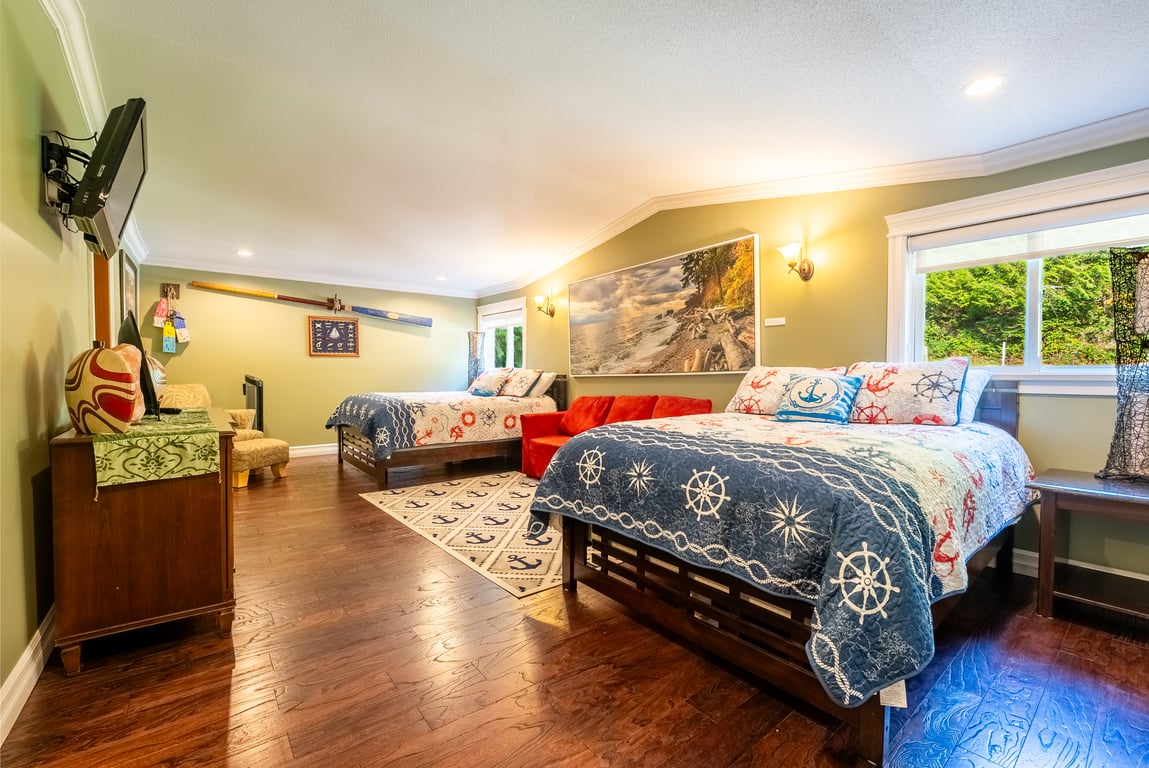 Spacious bedroom with two beds and nautical quilts