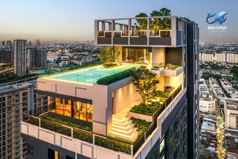 Stunning rooftop infinity pool overlooking a city skyline at dusk, with modern lounging areas and lush greenery.