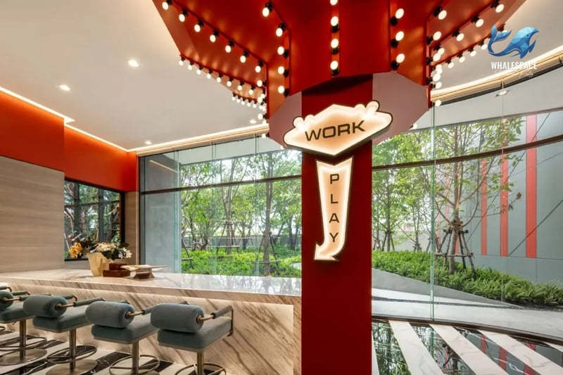 Vibrant coworking space with bar seating and large windows overlooking gardens