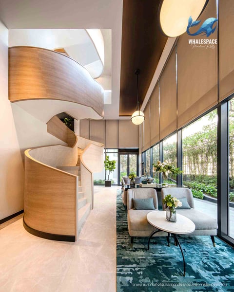 Elegant lounge area with comfortable seating, large windows offering garden views, and a striking spiral staircase.