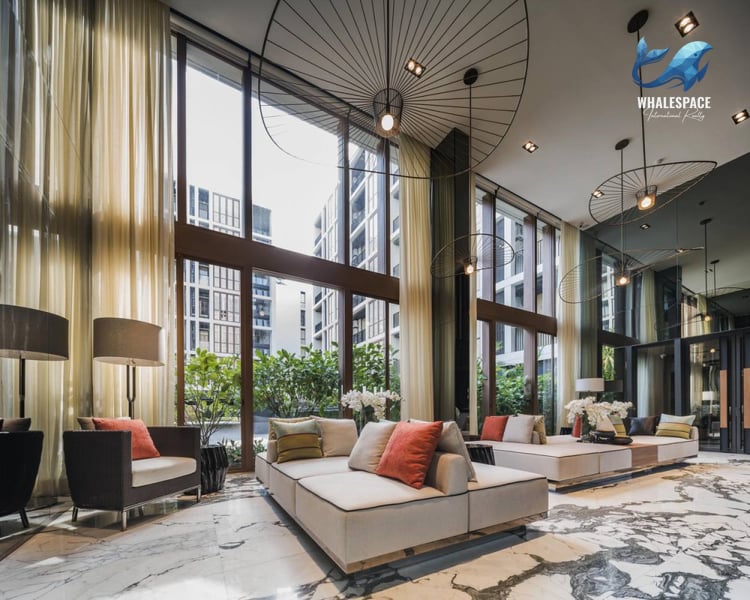 Elegant and spacious lobby with a striking marble floor, contemporary seating, and dramatic pendant lighting.