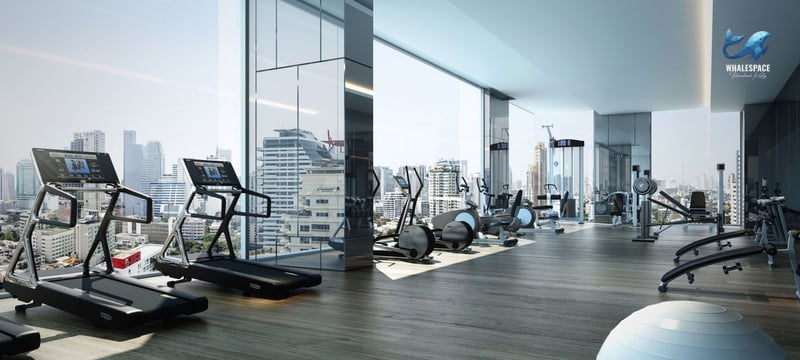 Modern fitness center with treadmills, ellipticals, and weight machines, offering panoramic city views