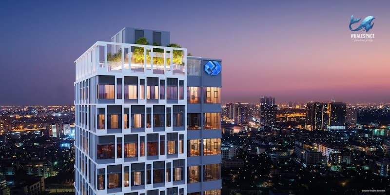 Modern high-rise building facade with city skyline at dusk