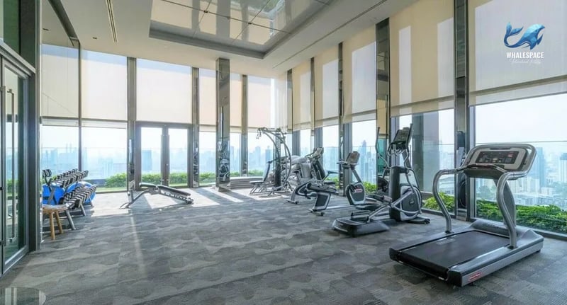 State-of-the-art gym featuring treadmills, weight machines, and dumbbell sets with expansive city views