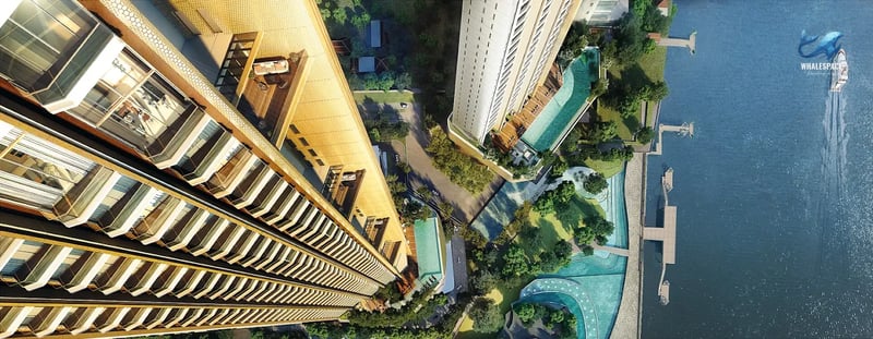 Aerial view of high-rise condominium buildings with multiple swimming pools, green spaces, and river frontage.