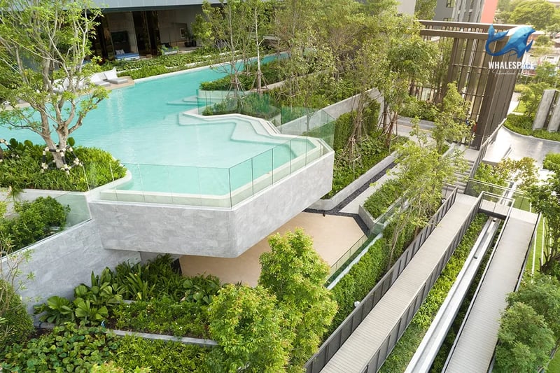 Cascading multi-level swimming pool complex nestled within landscaped gardens and concrete walkways