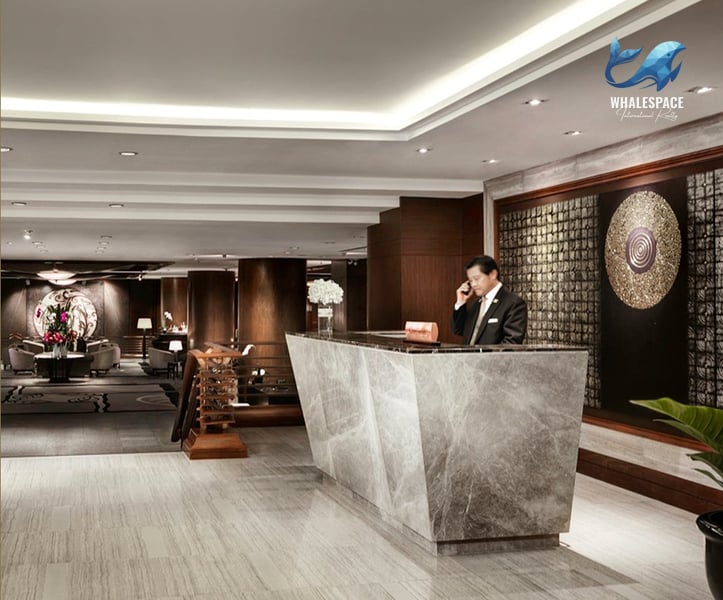 Elegant marble reception desk with a concierge attending to a guest.