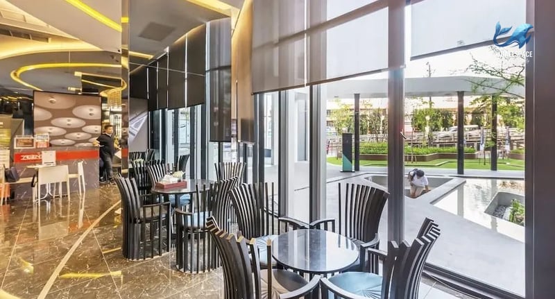 Elegant lounge area with designer chairs and tables, featuring views of the garden
