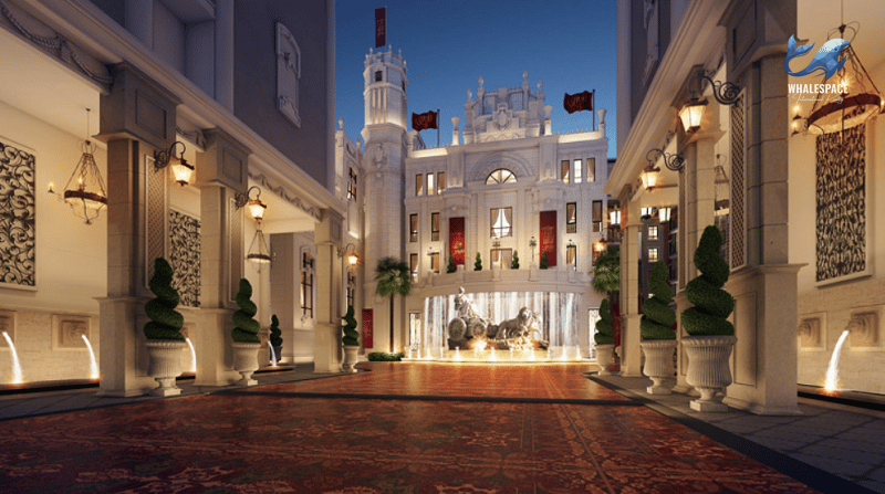 Grand entrance area with ornate classical architecture, illuminated archways, and a patterned driveway at dusk.