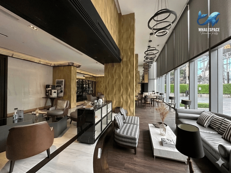 Sophisticated lobby lounge with diverse seating, dark wood accents, striking gold textured walls, and large windows.