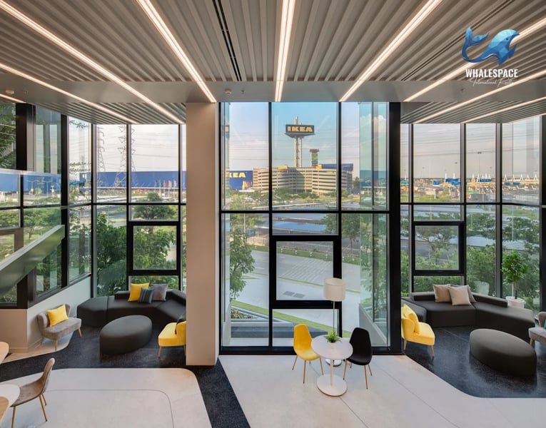 Spacious contemporary lounge area with comfortable seating and expansive windows offering city views.