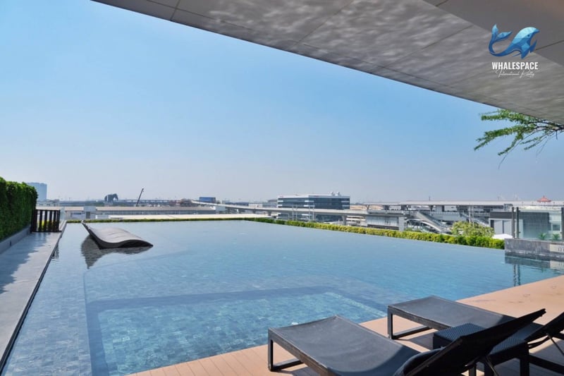 Panoramic view of an infinity pool with city skyline in the background.