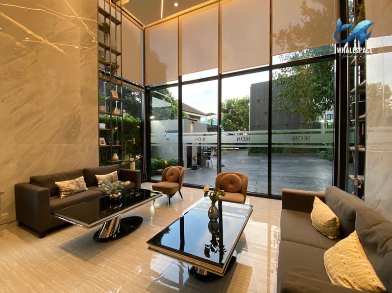Grand double-height lobby with high ceilings, marble floors, large windows, and contemporary seating.