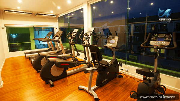 Well-equipped fitness center featuring treadmills, ellipticals, and stationary bikes, with large windows offering exterior views.