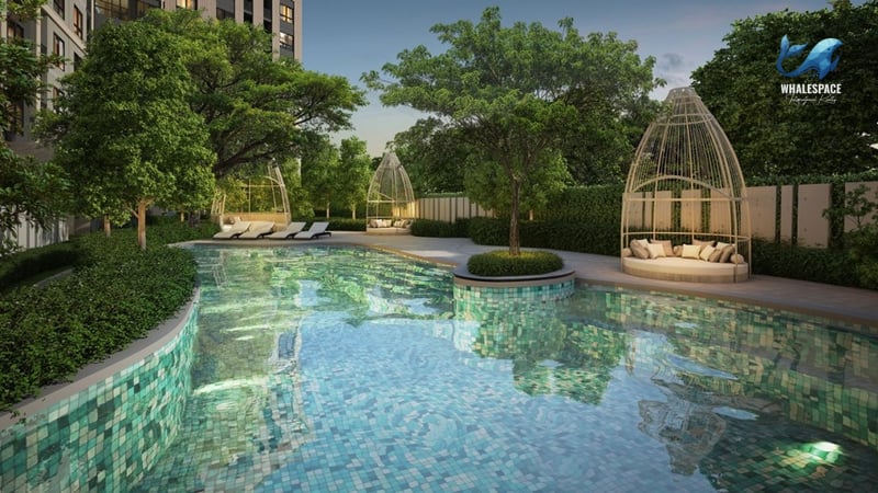 An inviting outdoor swimming pool with vibrant blue-green tiled steps and floor, surrounded by mature trees, sun loungers, and decorative pod-like cabanas.