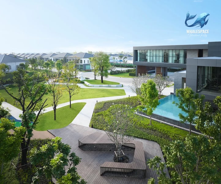 Expansive green lawn and seating area with modern architecture in the background
