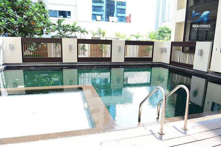 Outdoor swimming pool featuring a shallow integrated area and metal handrails for access