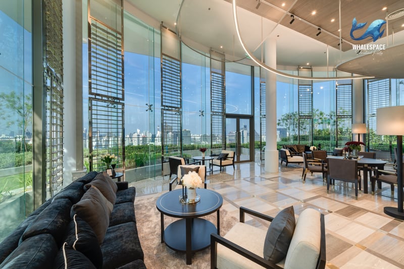 Luxurious lounge area with plush seating, elegant decor, and panoramic city views through floor-to-ceiling windows