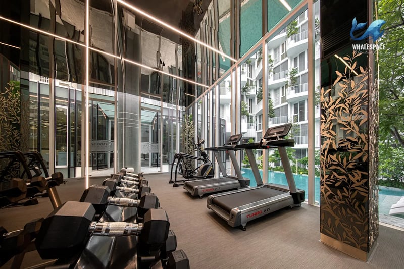 Well-equipped gym with treadmills and free weights, featuring expansive windows with pool and city views.