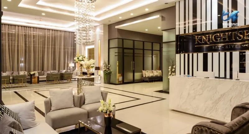 Luxurious and spacious lobby with elegant seating, a striking chandelier, and a modern reception desk.