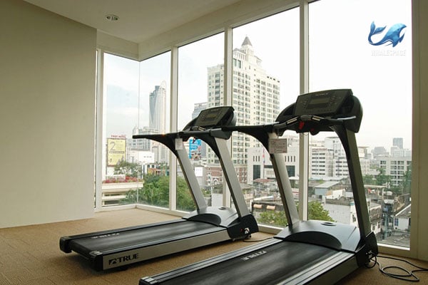 State-of-the-art fitness center with treadmills and expansive windows providing city vistas.