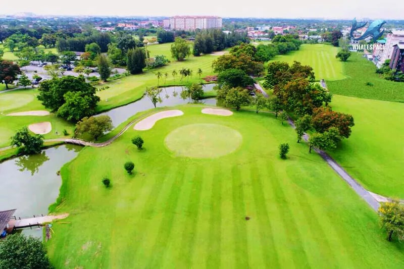 Expansive golf course with manicured fairways, water features, and lush trees.