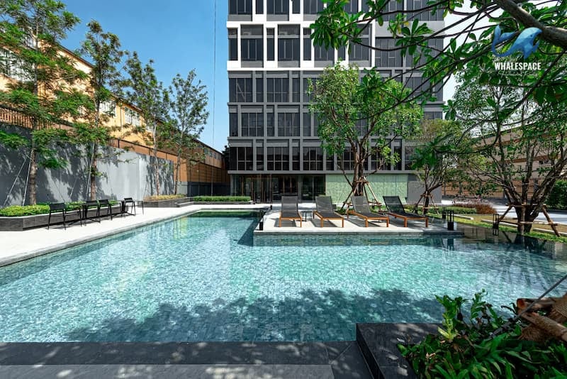 Serene outdoor swimming pool surrounded by lush greenery and lounge chairs