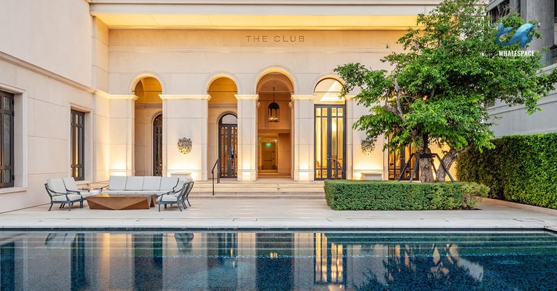Outdoor swimming pool with integrated lounge seating area and classic building architecture