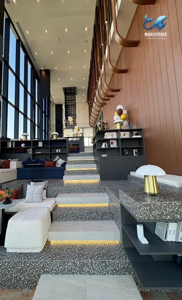 Multi-level lobby area with unique tiered seating, bookshelves, and contemporary lighting.