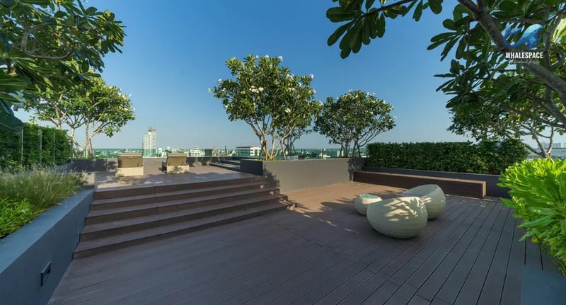 Elevated rooftop terrace with comfortable seating areas and lush landscaping, offering panoramic city views.