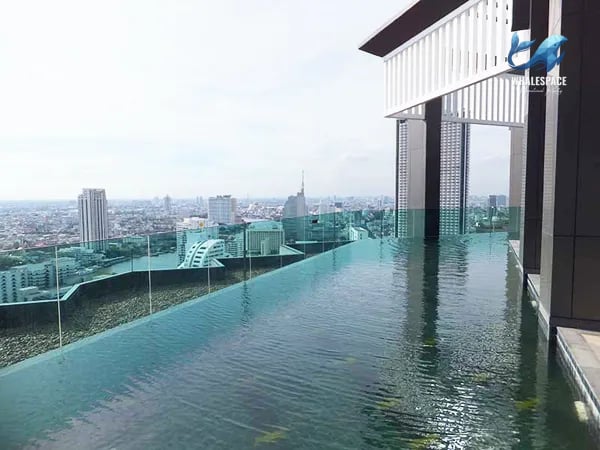Infinity pool with city skyline backdrop and reflective water surface.