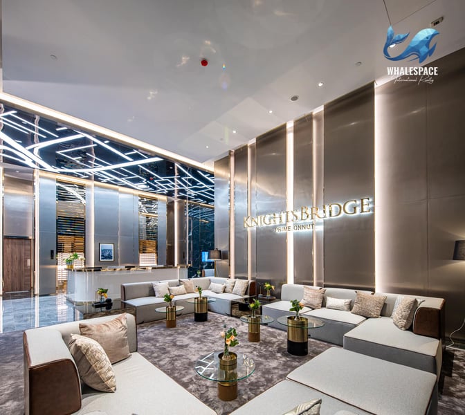 Elegant lobby with a reception desk and sophisticated seating arrangements, featuring modern lighting.