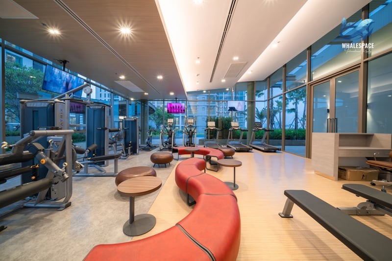 Well-equipped fitness center with modern exercise machines and ample space, featuring large windows overlooking the city