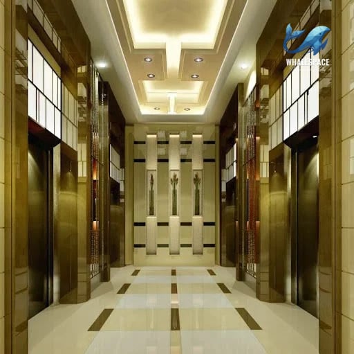 Luxurious elevator lobby with polished marble floors, ornate wall paneling, and golden accents.
